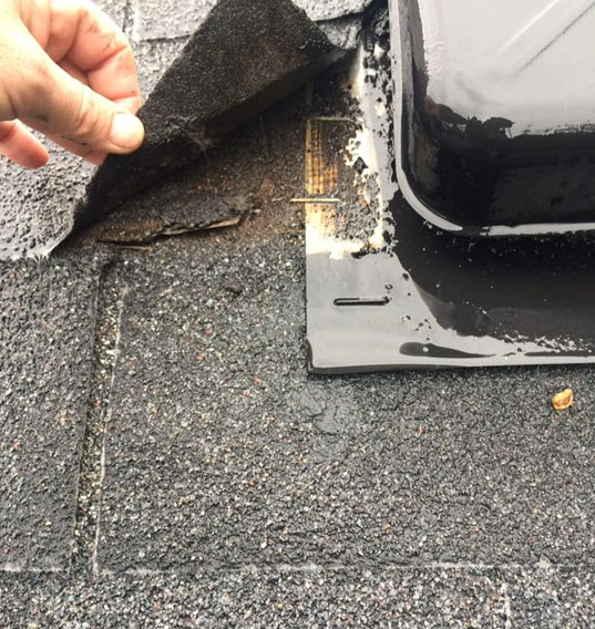 Roofer examines flashing damage before a repair job in Riverbank