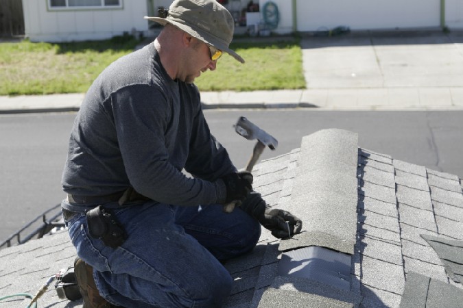 kelly roofer repairing residential grey asphalt shingle roof in Ripon ca