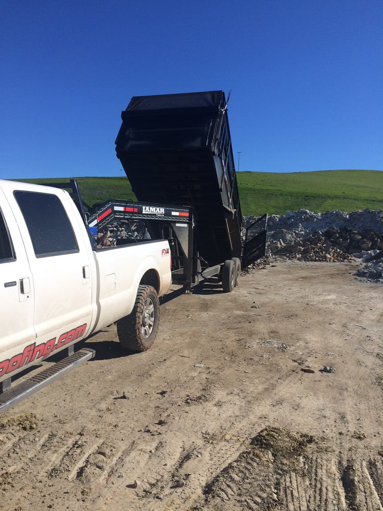 Kelly roofing truck and hauling trailer dumping storm damaged roof